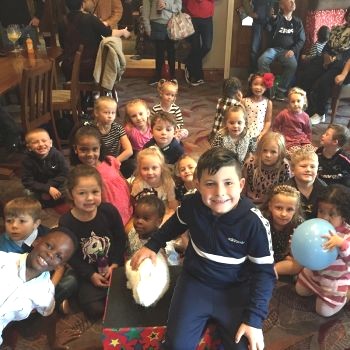 Snowy the rabbit delights the birthday star while party guests clap and cheer in Chesterfield.