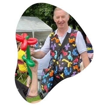 Magic Stuart mingling with guests while creating balloon animals at a Derby even