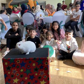 A group of children laughing and clapping during a birthday party show in Alfreton