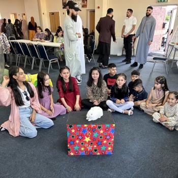 A group of children laughing and clapping during a birthday party show in Ashbourne