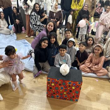 A group of children laughing and clapping during a birthday party show in Beeston