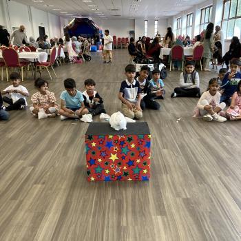 A group of children laughing and clapping during a birthday party show in Bestwood