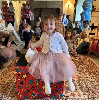 A group of children laughing and clapping during a birthday party show in Chellaston