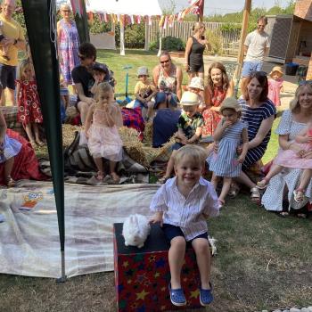 A group of children laughing and clapping during a birthday party show in Chesterfield