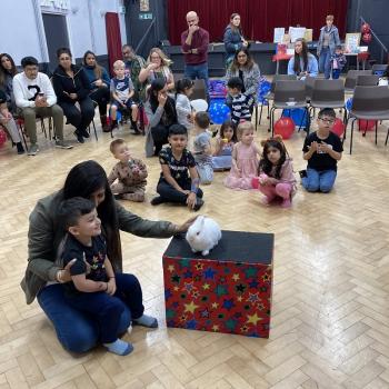 A group of children laughing and clapping during a birthday party show in Grantham