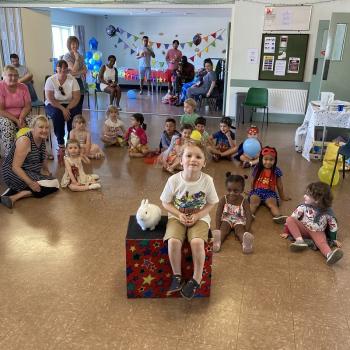 A group of children laughing and clapping during a birthday party show in Ilkeston