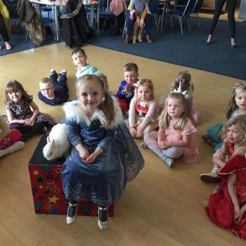 A group of children laughing and clapping during a birthday party show in Kegworth