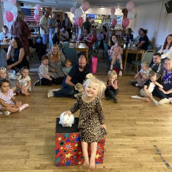 A group of children laughing and clapping during a birthday party show in Kirkby In Ashfield