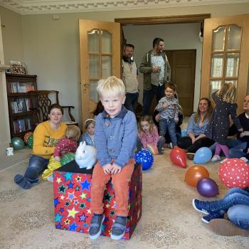 A group of children laughing and clapping during a birthday party show in Mansfield