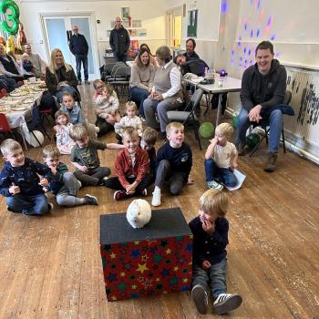 A group of children laughing and clapping during a birthday party show in Matlock