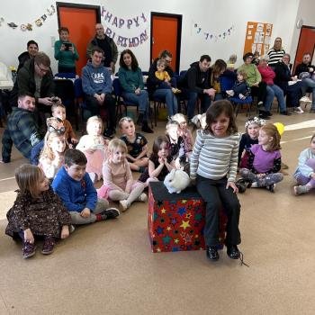 A group of children laughing and clapping during a birthday party show in Newark