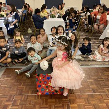 A group of children laughing and clapping during a birthday party show in Nottingham
