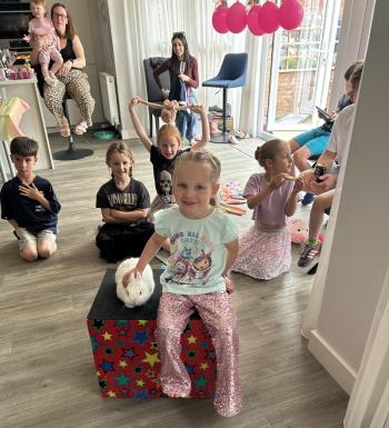 A group of children laughing and clapping during a birthday party show in Sheffield