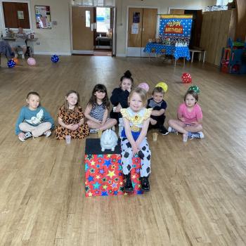 A group of children laughing and clapping during a birthday party show in Stafford