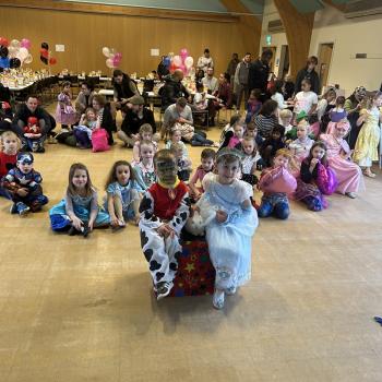 A group of children laughing and clapping during a birthday party show in West Bridgford