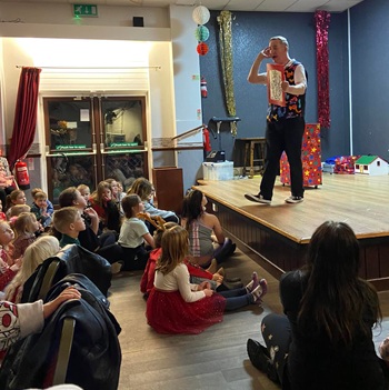 Children's entertainer performing an interactive fun magic show at a christmas party in Ashbourne