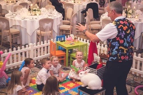 Magic Stuart presenting a live magic show with Snowy the rabbit at a wedding